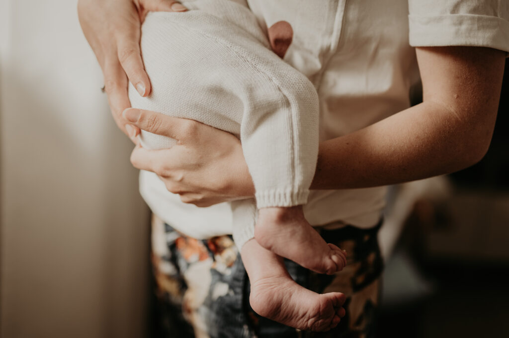 Détails des mains de bébé pendant une séance photo naissance