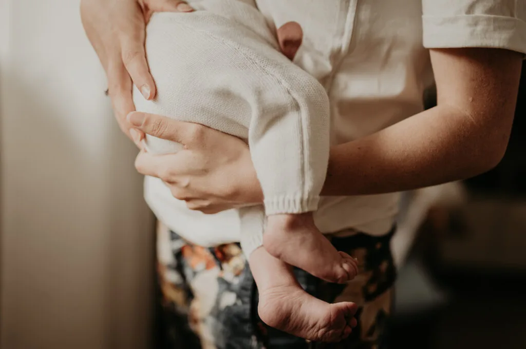 Détails des mains de bébé pendant une séance photo naissance