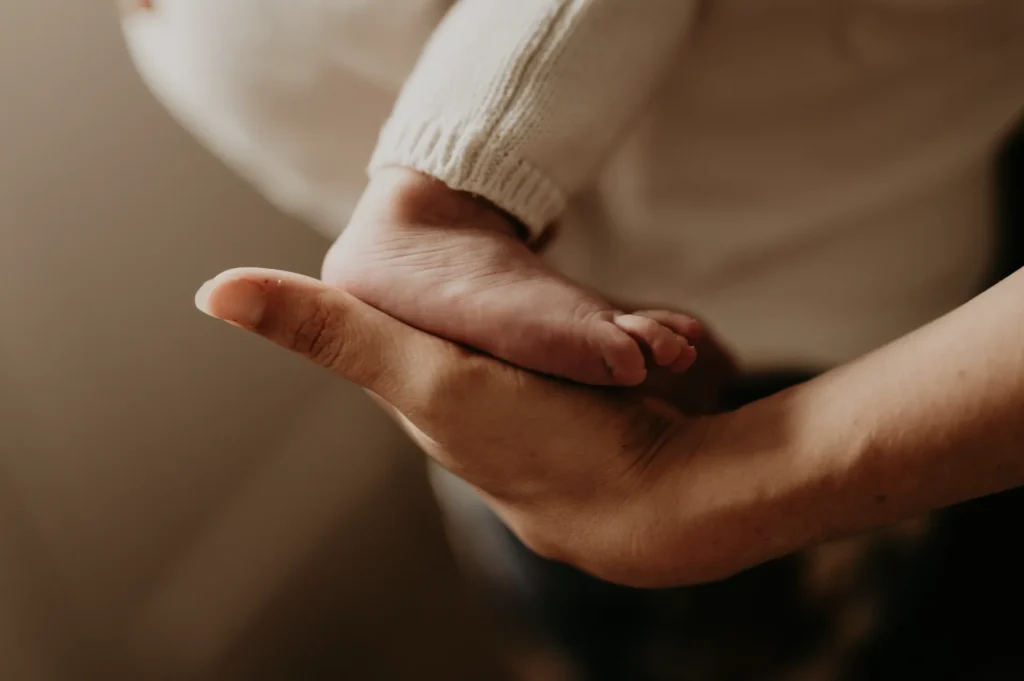 Détails des mains de bébé pendant une séance photo naissance